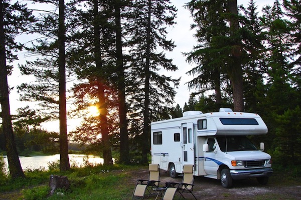 RV at camp in woods by lake